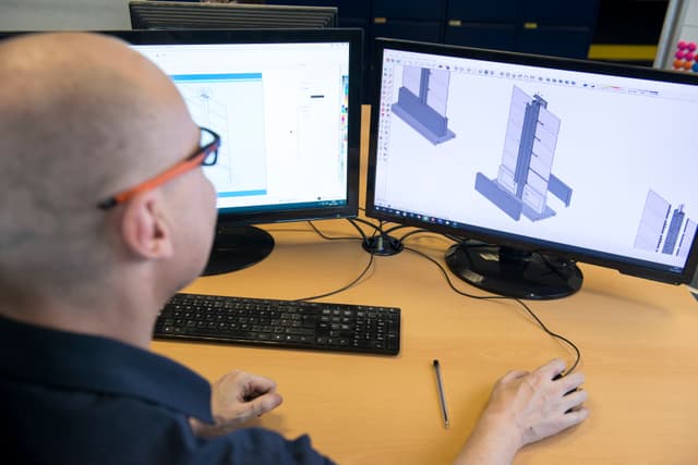 Over the shoulder view of custom signage being designed in CAD software.